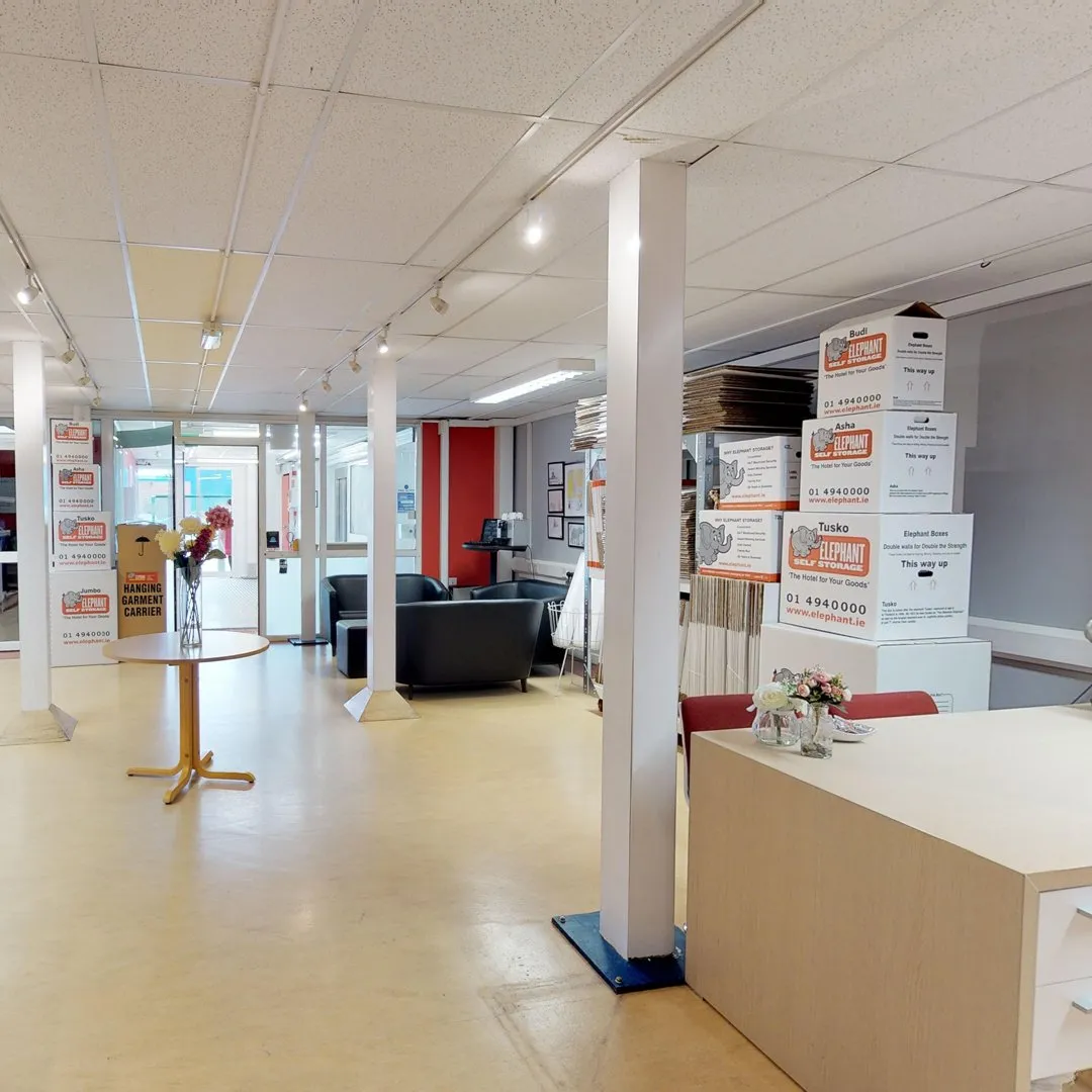 A spacious office filled with furniture and boxes, showcasing Elephant Click & Store facilities.