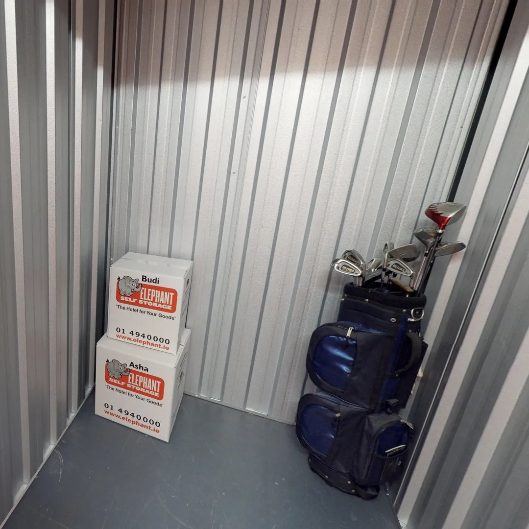 A storage unit at Elephant Click & Store facilities filled with golf bags and boxes.