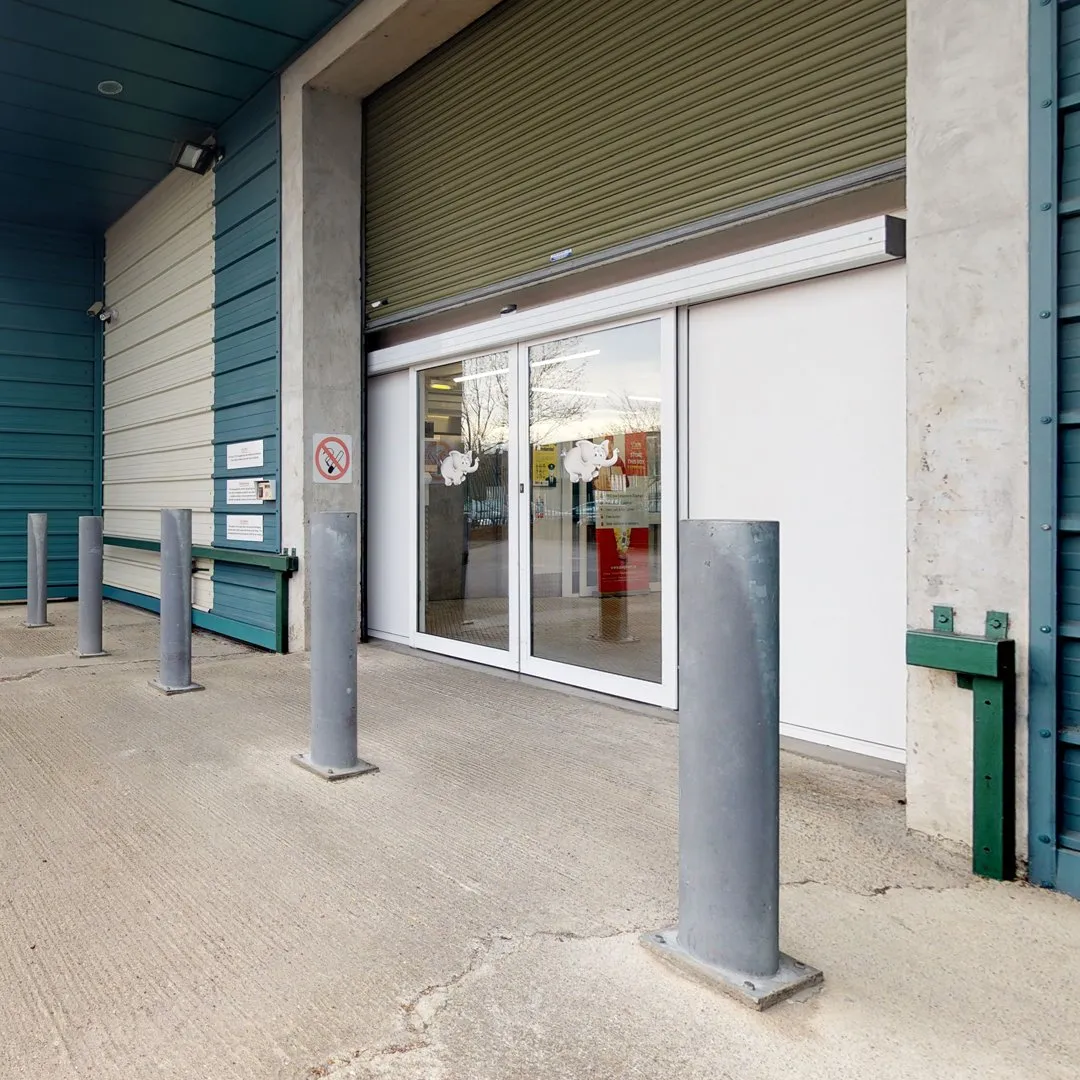 A large building with a large door and a few poles, part of Elephant Click & Store facilities.