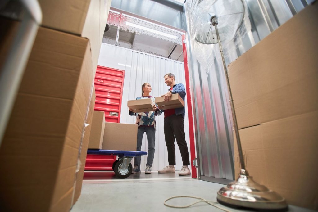 A man and woman organizing boxes in a storage unit.
