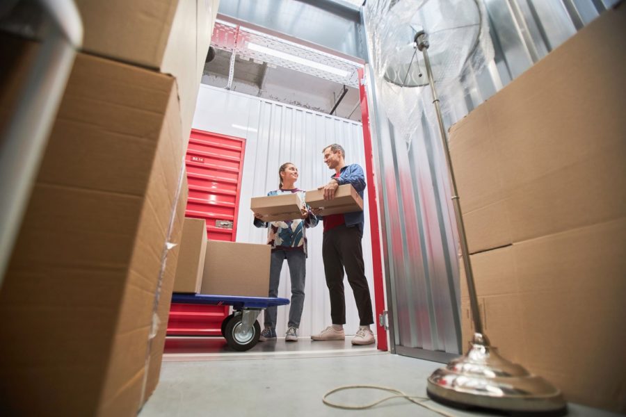 A man and woman organizing boxes in a storage unit.