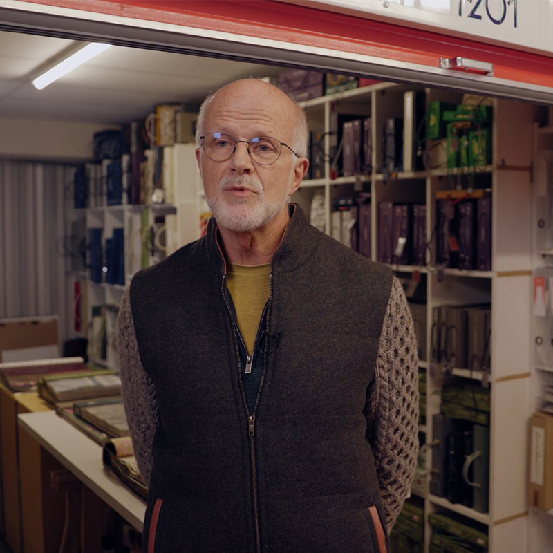 A man standing in front of a shelf of books at Elephant Click and Store facilities.