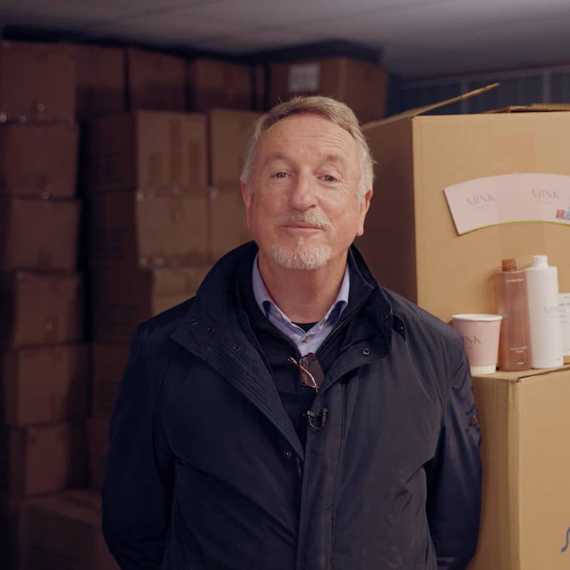 1. A man standing in front of boxes at Elephant Click and Store facilities.