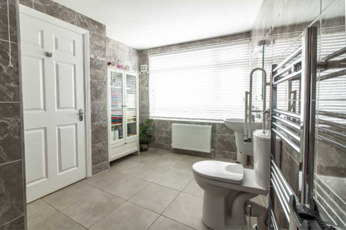 A bathroom with a toilet, sink, and shower.