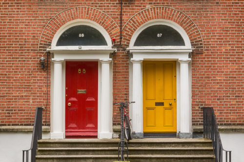 Two colorful doors with bicycles parked in front of them in Dublin.