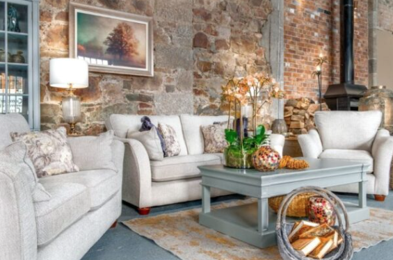 Living room with stone walls, wooden furniture, and a cozy atmosphere.