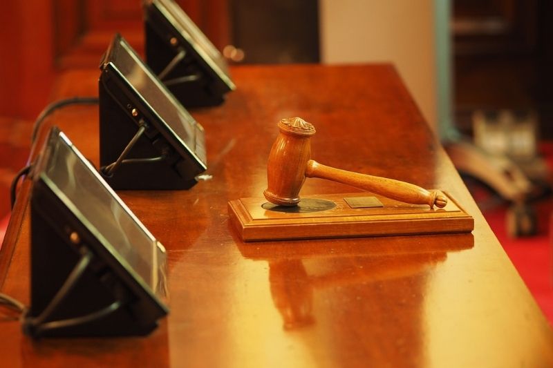 A judge's gavel resting on a wooden desk.