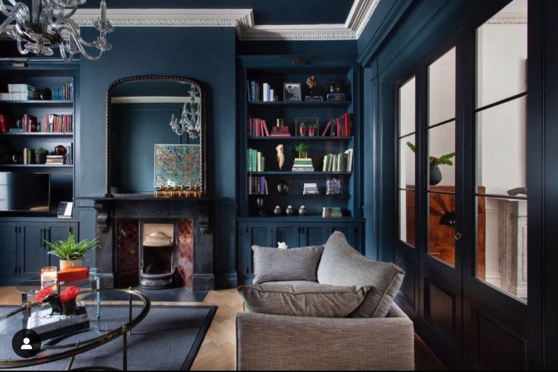 A cozy living room with blue walls and a fireplace, creating a serene ambiance.