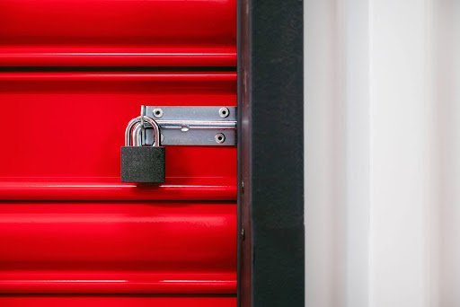 A red storage locker with a padlock on it, providing secure storage for personal belongings.